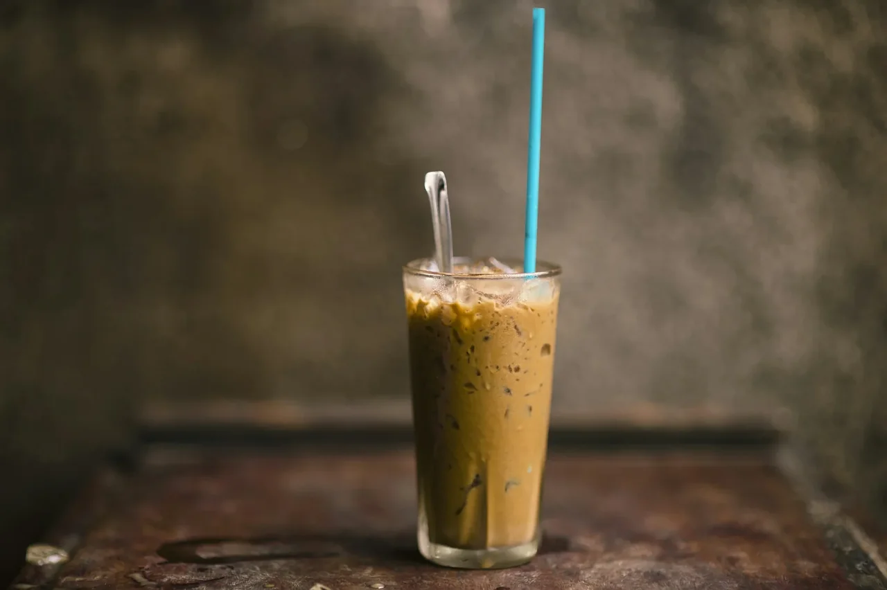 A glass of Vietnamese iced milk coffee on a wooden table, shown as serving inspiration.